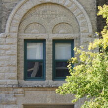 Image 8: Two windows with dark green surrounds encompassed by an arch