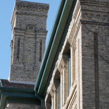 Image 11: Looking up at roof cornice and detailed stone chimney