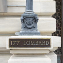 Image 4: A stone base near the entrance that has a sign that reads "177 Lombard"