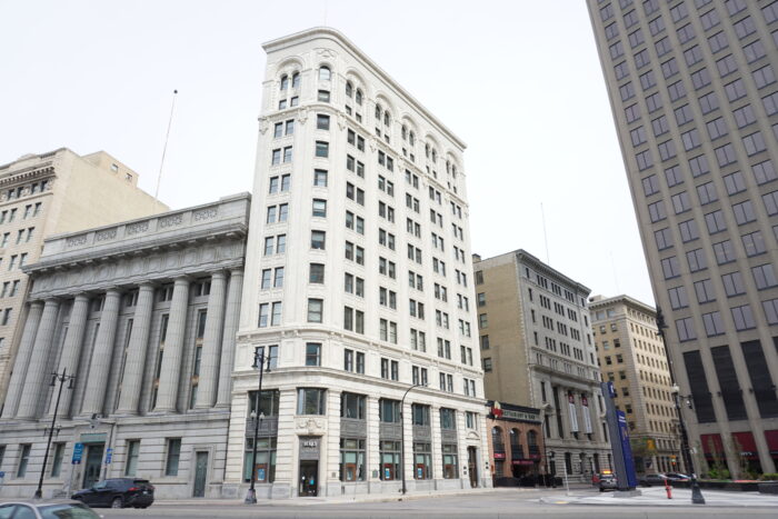 The Union Trust Building with buildings on both sides of it and streetlights in front.