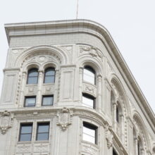 Image 3: Looking up at the Union Trust Building featuring the decorative cornice and other details on the facade