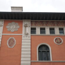 Image 6: Top floor row of windows and decorative medallions on side of Birks Building