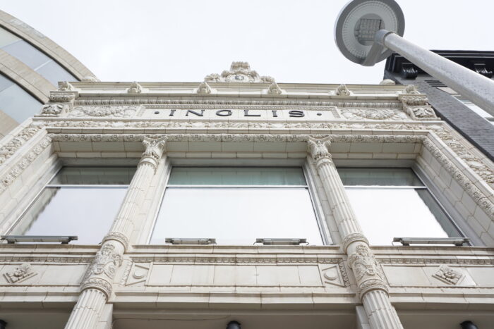 Looking up at the front facade of the Inglis Building. A streetlight is in front of the building.