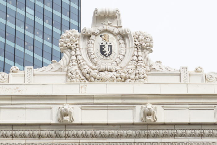 Ornamentation, including a crest, at the top of the facade above the front entrance of the Inglis Building.