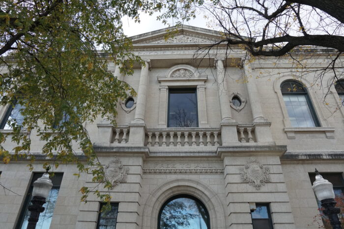 Looking up at the front facade of Winnipeg’s Carnegie Library with “FREE TO ALL” carved in stone above the entrance.