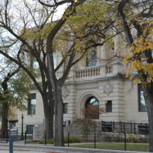 Image 4: Front entrance of Carnegie Building behind wrought-iron gate and tree in front