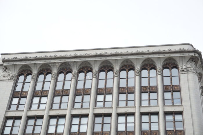 The ornamentation along the top storey and roofline of the Paris Building.