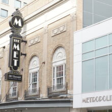 Image 4: The original facade of the Metropolitan theatre alongside the newer addition featuring a sign that reads "The Met"