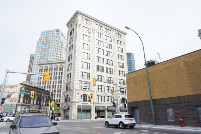 Le bâtiment Lindsay avec des bâtiments autour. La circulation et les feux de signalisation sont au premier plan.  