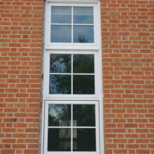 Image 1: Vertical tri-window set into brick wall