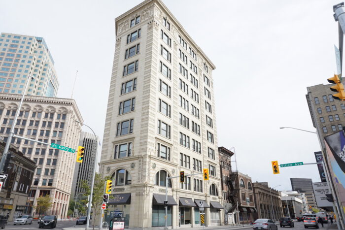 Le bâtiment Lindsay. Des feux de signalisation avec des panneaux indiquant "Garry St" et "Ellice Ave" de chaque côté.  