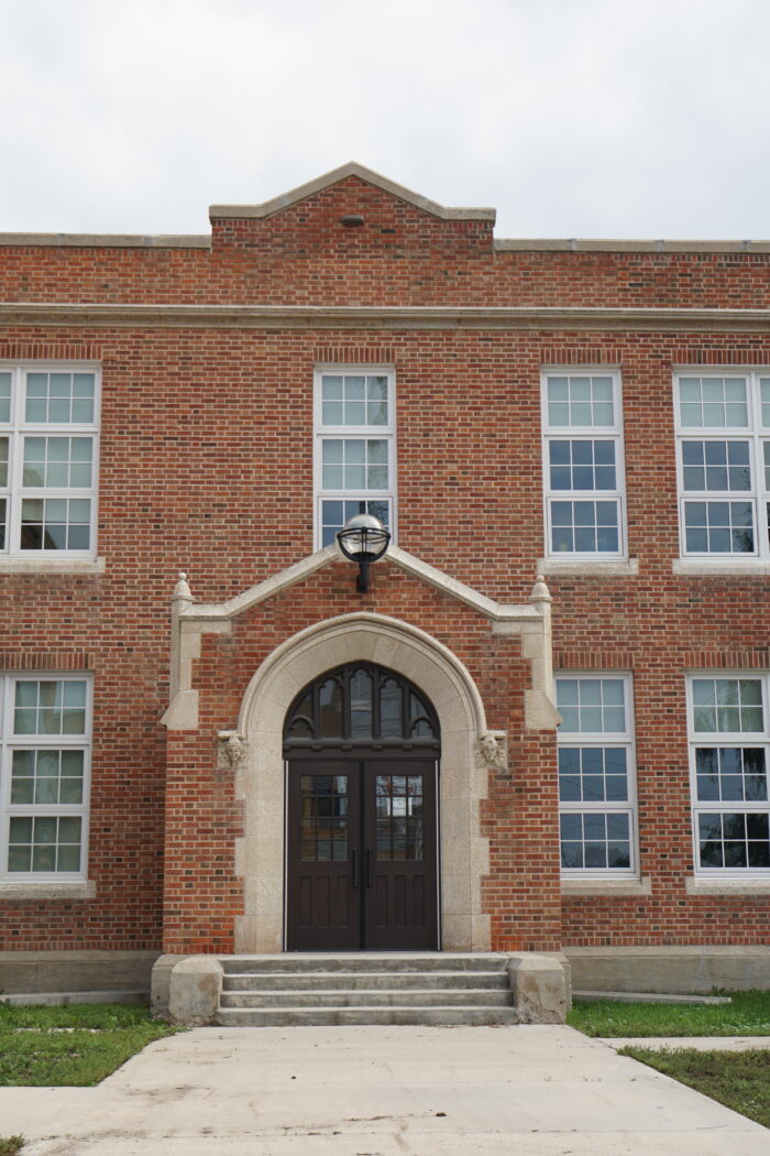 A set of entrance doors to MacKenzie School with a light fixture above.