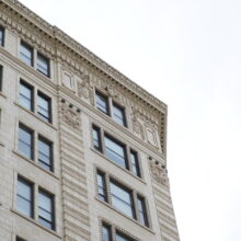 Image 9 : Regardant le coin du bâtiment Lindsay présentant des détails architecturaux décoratifs sur les murs extérieurs  