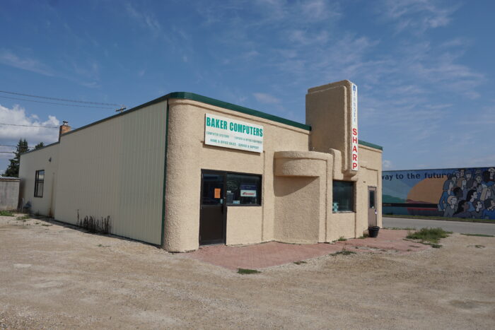 Greenings Garage building with a sign reading “Baker Computers” on the front.