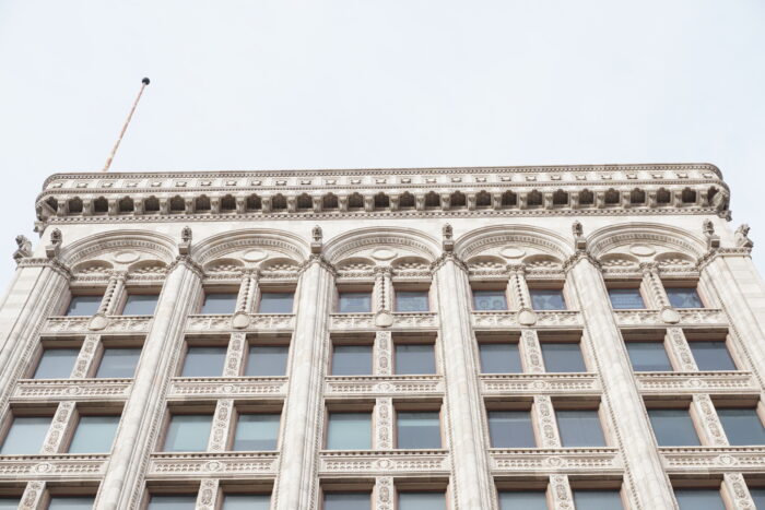 The ornamentation and cornice along the top three storeys of the Railway Chambers Building.