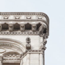 Image 2: One of the top corners of the Railway Chambers Building featuring decorative architectural details of the cornice