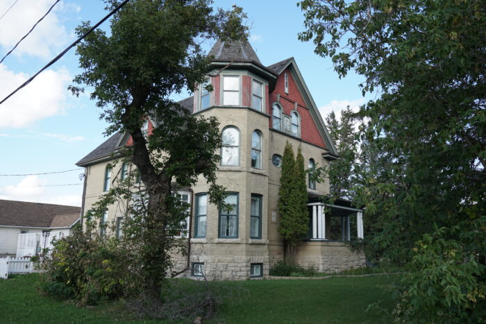 Myers House with trees in the foreground obscuring part of the facade.