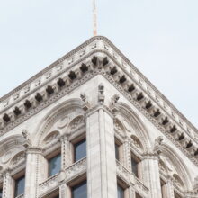 Image 3: One of the top corners of the Railway Chambers Building featuring decorative architectural details of the cornice