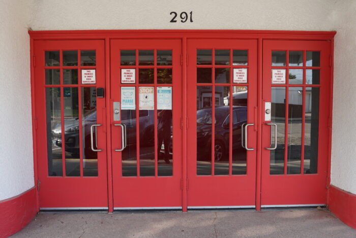 The red front doors of the Roxy Theatre with the number 291 above.