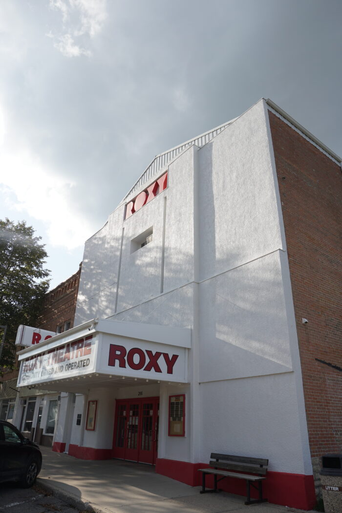 The Roxy Theatre with a bench on the sidewalk in front of the building.