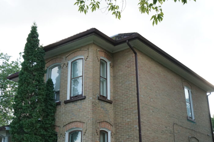 Extension protruding from building with segmental arch above double-hung windows