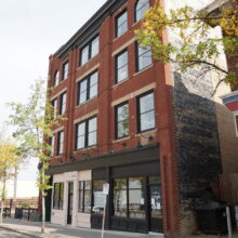 Image 1: The Campbell & Campbell Building with a tree and no parking sign in front.