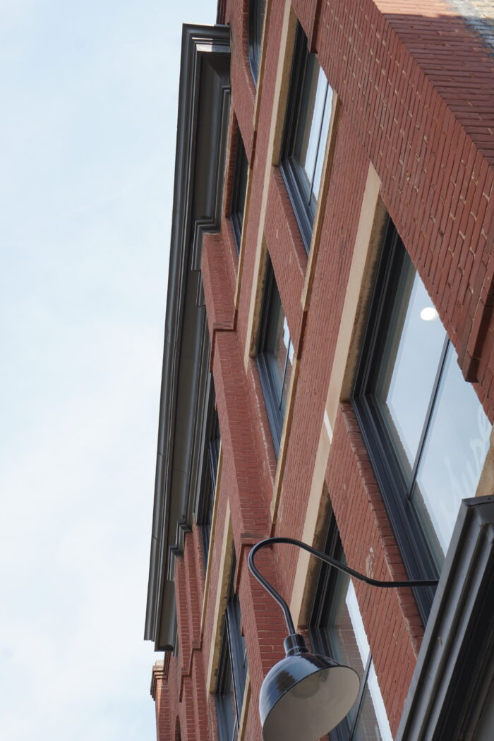 Looking up at the front facade of the Campbell & Campbell Building with a light fixture in the foreground.