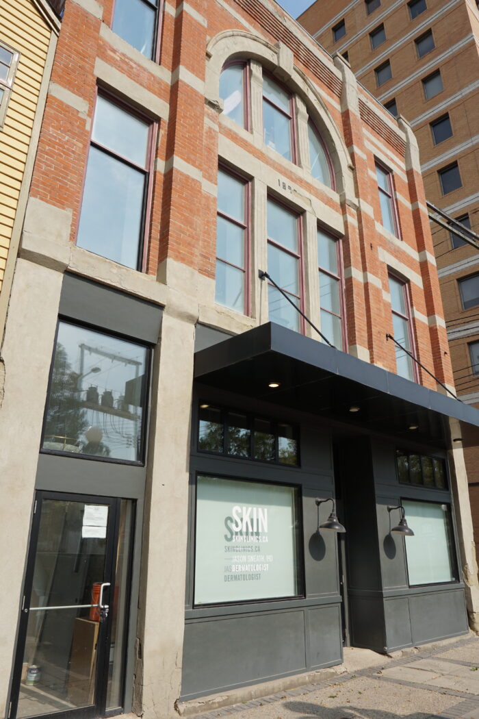 The Fraser Block with a marquee over the front entrance. Two light fixtures frame the main doors.