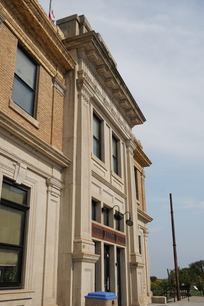 Close up of façade showing Doric pilasters protruding around the doorway.