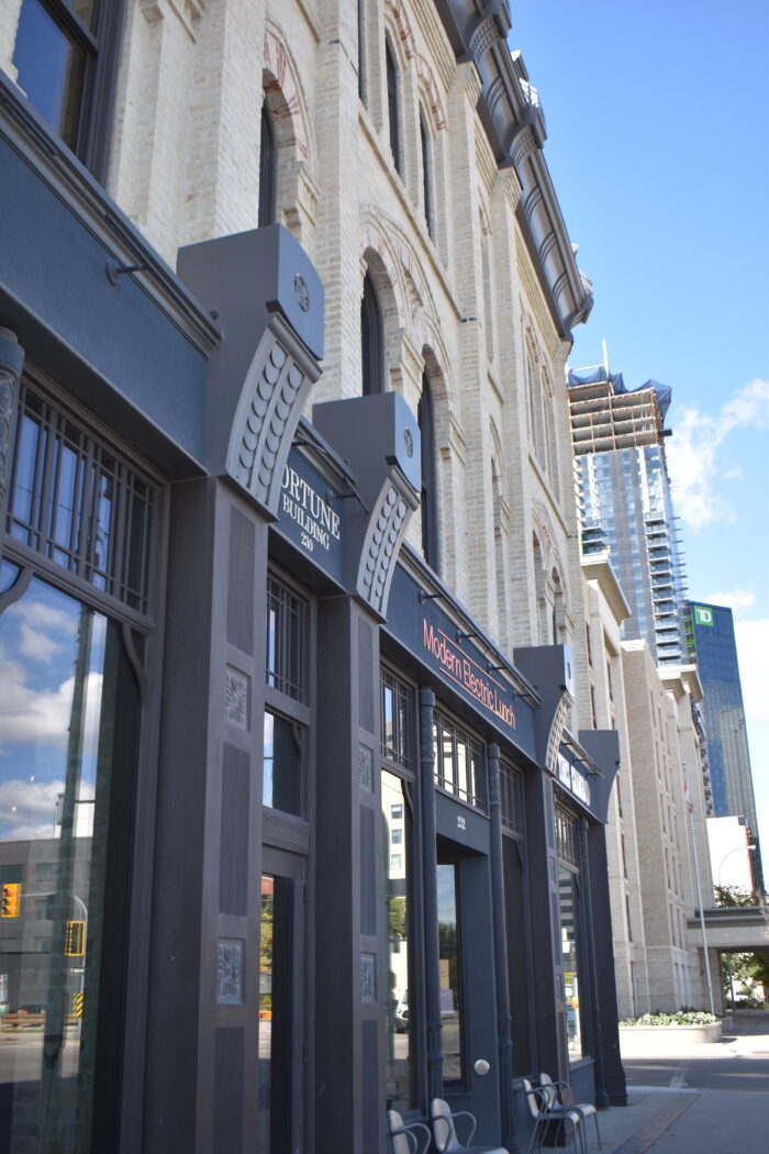 The Fortune / Macdonald Block with chairs on the sidewalk up against the building.