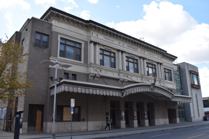 Winnipeg’s Pantages Theatre with the text “UNEQUALLED PANTAGES VAUDEVILLE” on the front facade. A person walks by.