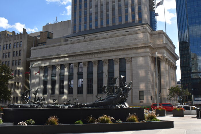 The side of Winnipeg’s downtown Bank of Montreal building. A sculpture of caribou parades across the foreground.