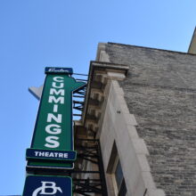 Image 1: Hanging sign on the facade of the brick building that reads "Burton Cummings Theatre"