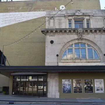 The front entrance of the Walker Theatre. A sign reading “CUMMMINGS THEATRE” projects from the facade.