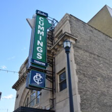 Image 7: Hanging sign on the facade of the brick building that reads "Burton Cummings Theatre"