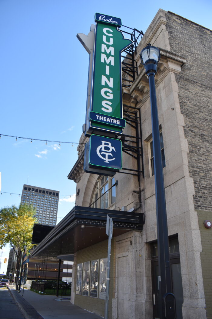 Side view of the facade with canopy and a large vertical sign that reads 'Burton Cummings Theatre.