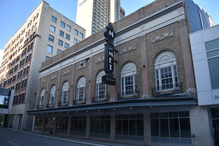 Winnipeg’s Metropolitan Theatre surrounded by buildings. A sign on the front reads “THE MET” and “281 Donald.”