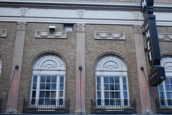 The windows on the second storey of Winnipeg’s Metropolitan Theatre. A sign on the facade reads “THE MET.”