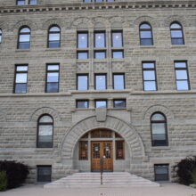 Image 1: Front facade of Wesley Hall featuring steps up to the main wooden doors