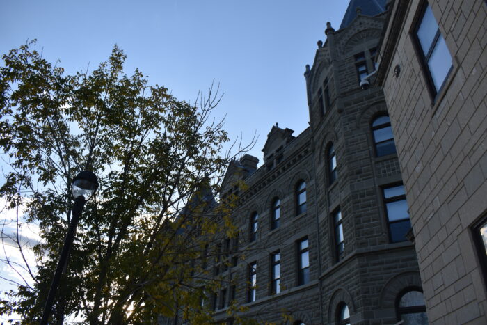 Two rows of windows are positioned above belt course. The top row of windows features segmented arches.