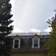 Image 1: Two dormer windows below a railing cornice