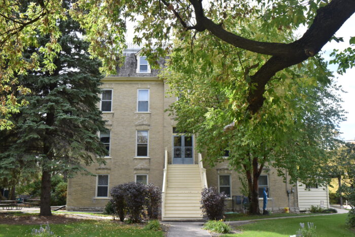 The Sisters of the Holy Name Convent with trees in front obscuring most of the facade.