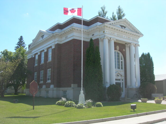 A Canadian flag flies on a flagpole in front of the Emerson Town Hall/Court House.