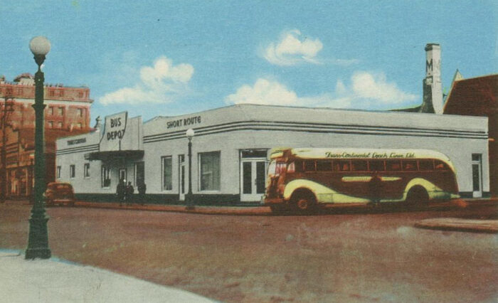 Image 2: The Brandon Bus Depot with a car and bus parked around it, accompanied by four people.